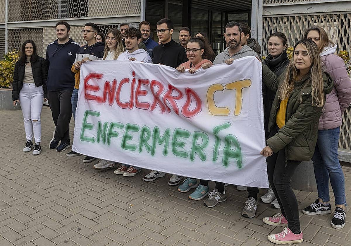 Alumnos de la Escuela de Enfermería, ayer, sostienen una pancarta en la puerta del aulario de Antiguones.
