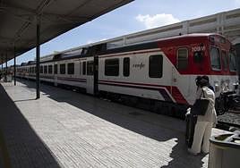 Una mujer con su maleta se prepara para subir al tren de cercanías.