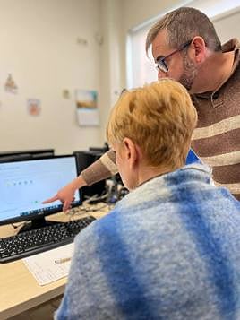 Un formador de Aula Nova, dirigiéndose a una alumna.