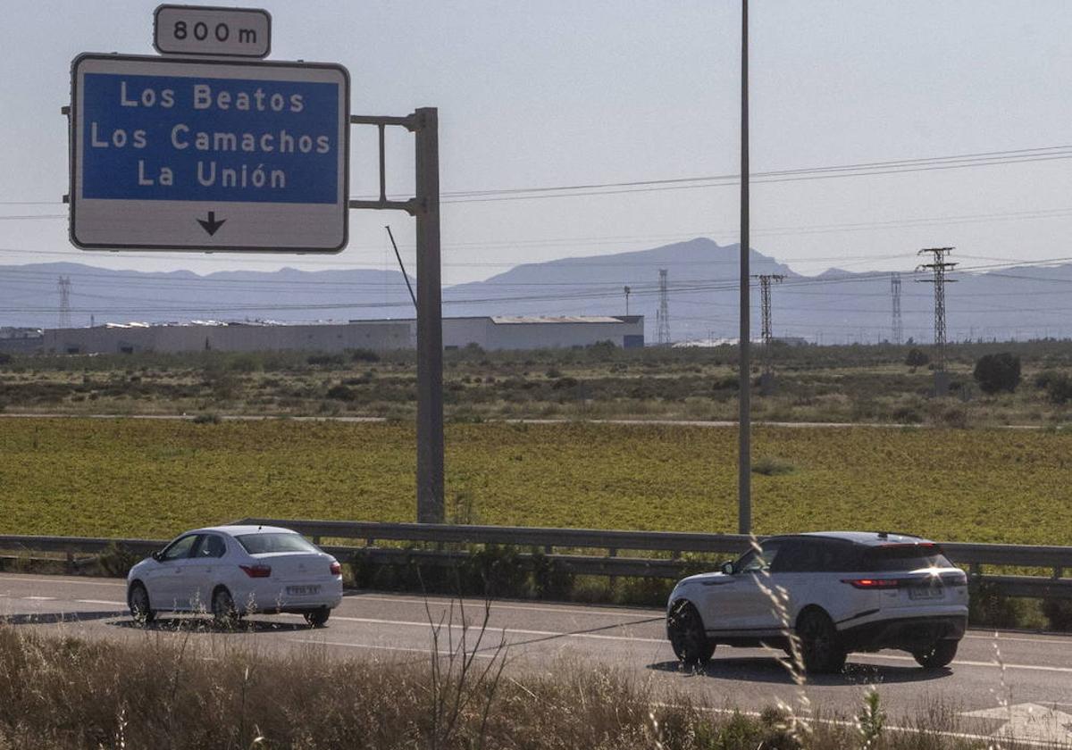 Dos coches pasan junto a los terrenos de la futura ZAL.