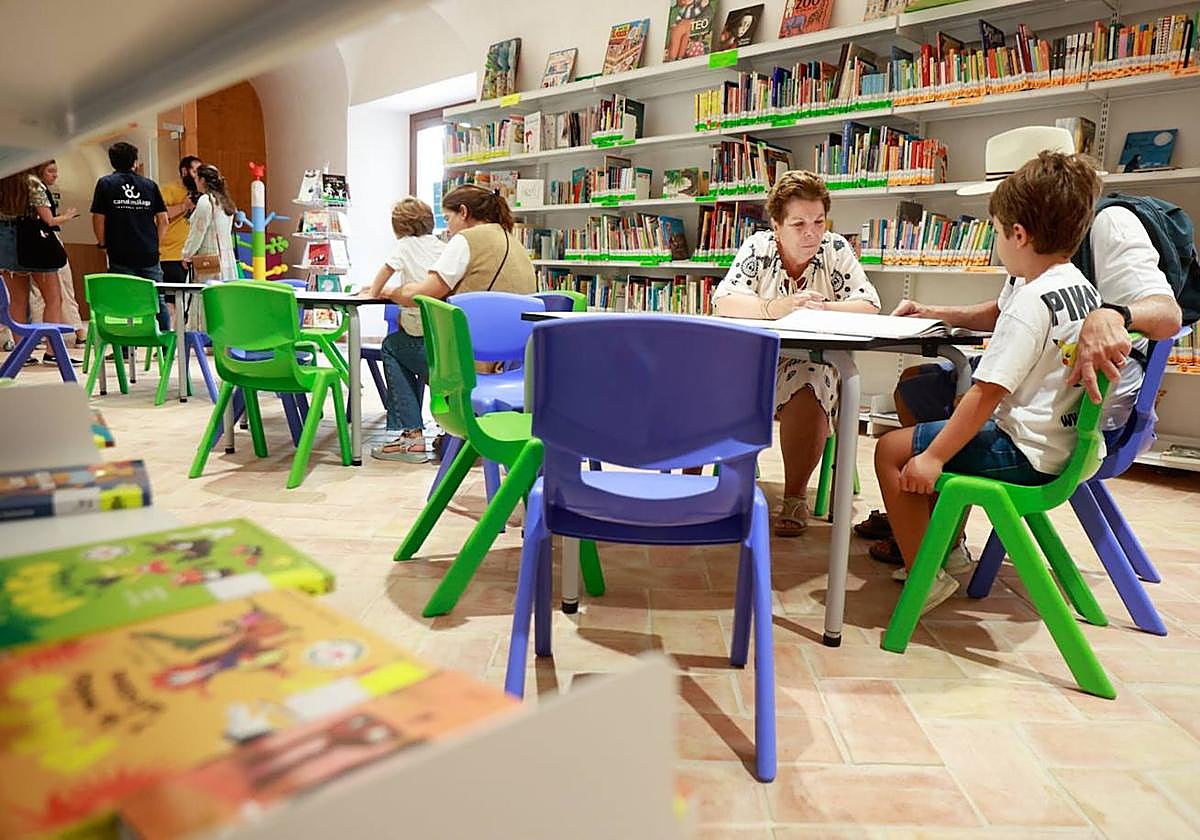 Niños leen en una sala infantil de una biblioteca.