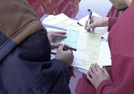 Dos conductores rellenan un parte amistoso al seguro.