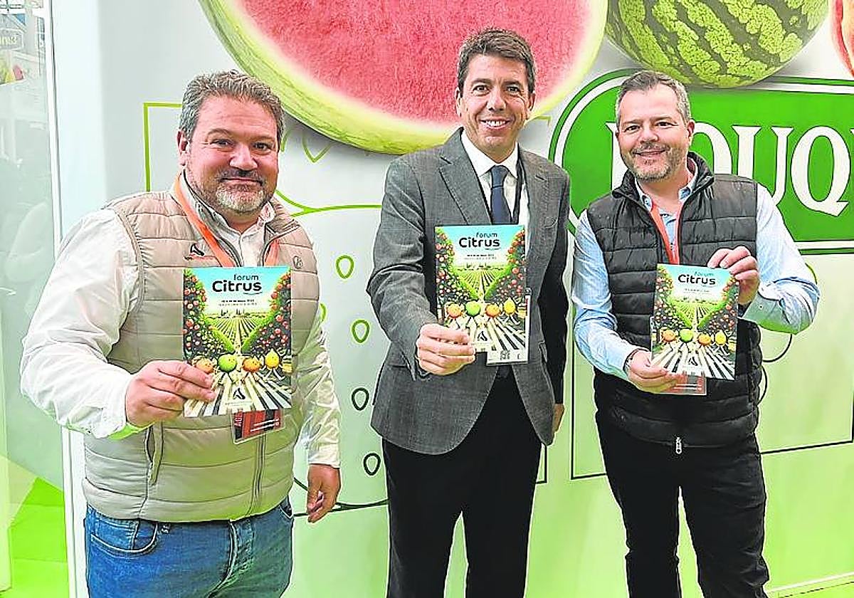El presidente de la Comunidad Valenciana, Carlos Mazón (c), flanqueado por los socios fundadores de Agromarketing, Antonio Santos (i) y Arturo Soler, en Fruit Logistica.