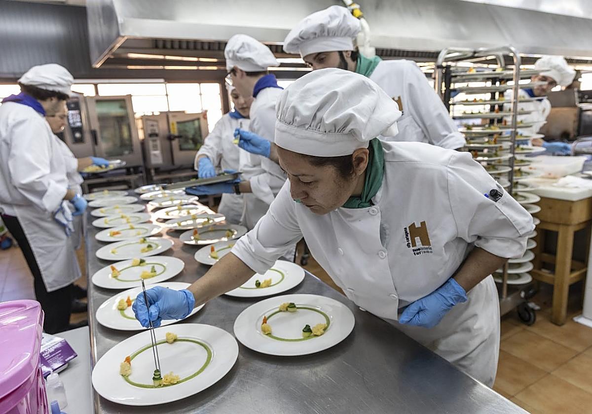 Un grupo de alumnos de la Escuela de Hostelería prepara uno de los platos que fueron servidos ayer durante la jornada de acogida a empresarios y proveedores.