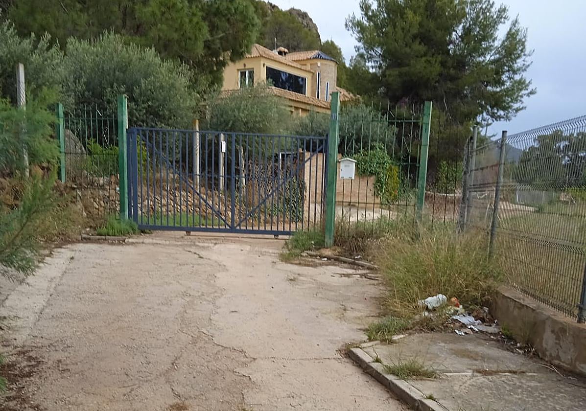 El camino de uso público, atravesado por una valla.