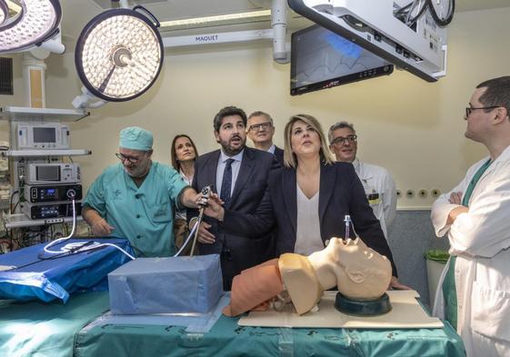 Un cirujano da un laparoscopio a Noelia Arroyo, que está junto a Fernando López Miras en un quirófano del hospital Santa Lucía.