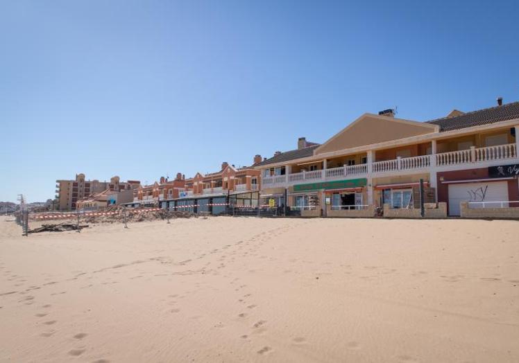 Hilera de construcciones erigidas sobre la misma arena de la playa de La Mata.