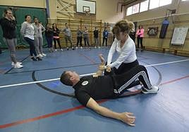 Dos agentes muestran a las mujeres una de las técnicas de autodefensa ante una agresión.