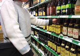 Una mujer compra bebidas alcohólicas en un supermercado.