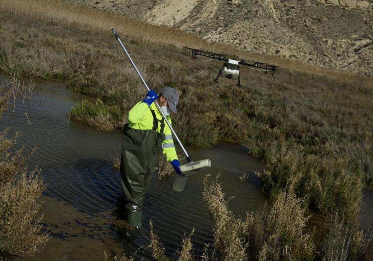 Un operario trabaja con un dron sobre el cauce de la rambla de Tabala.