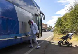 Un vecino de Los Urrutias abre el maletero del autobús para subir la silla de su bebé.