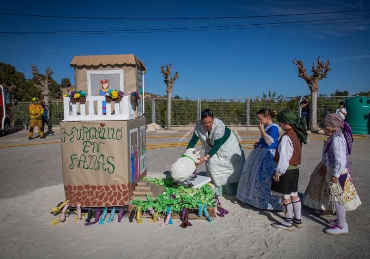 Un grupo de alumnos recata del monumento al 'ninot indultat'.