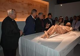 Autoridades contemplando la escultura hiperrealista.