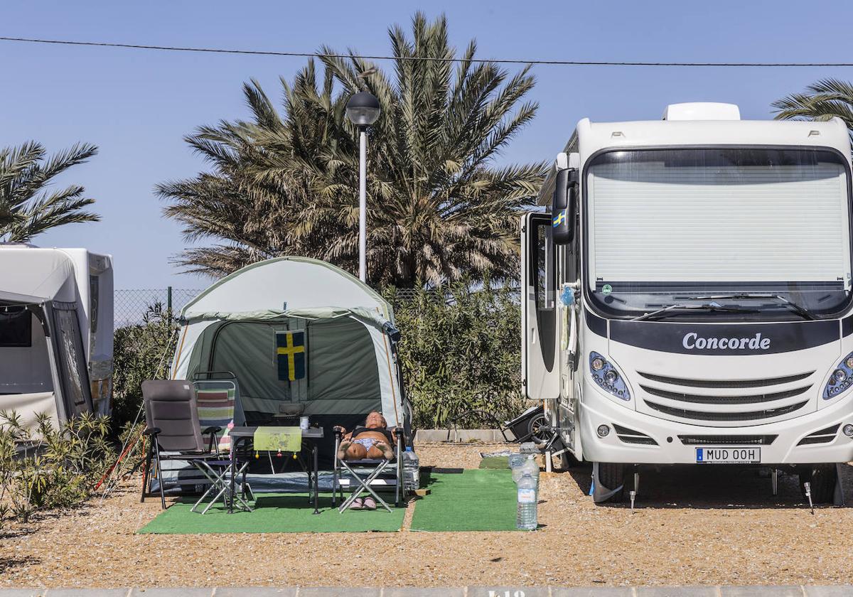 Una mujer extranjera toma el sol junto a su caravana en la parcela que tiene alquilada en el Camping Mar Menor, ubicado entre La Ribera y Los Alcázares.