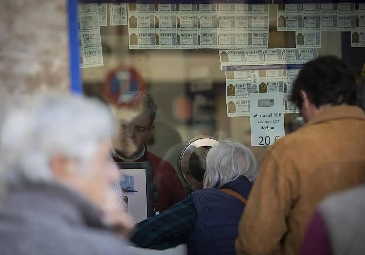 Los premidos hacen cola para recibir el dinero que han ganado en la Lotería del Niño.