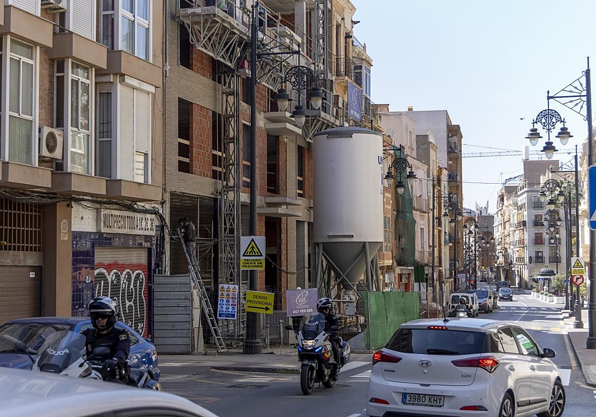 Varios vehículos pasan frente al edificio en construcción de la calle Duque que albergará pisos turísticos.