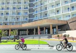 Dos personas pasan en bicicleta junto a las instalaciones del hotel Aluasun Doblemar, en La Manga, el pasado fin de semana.