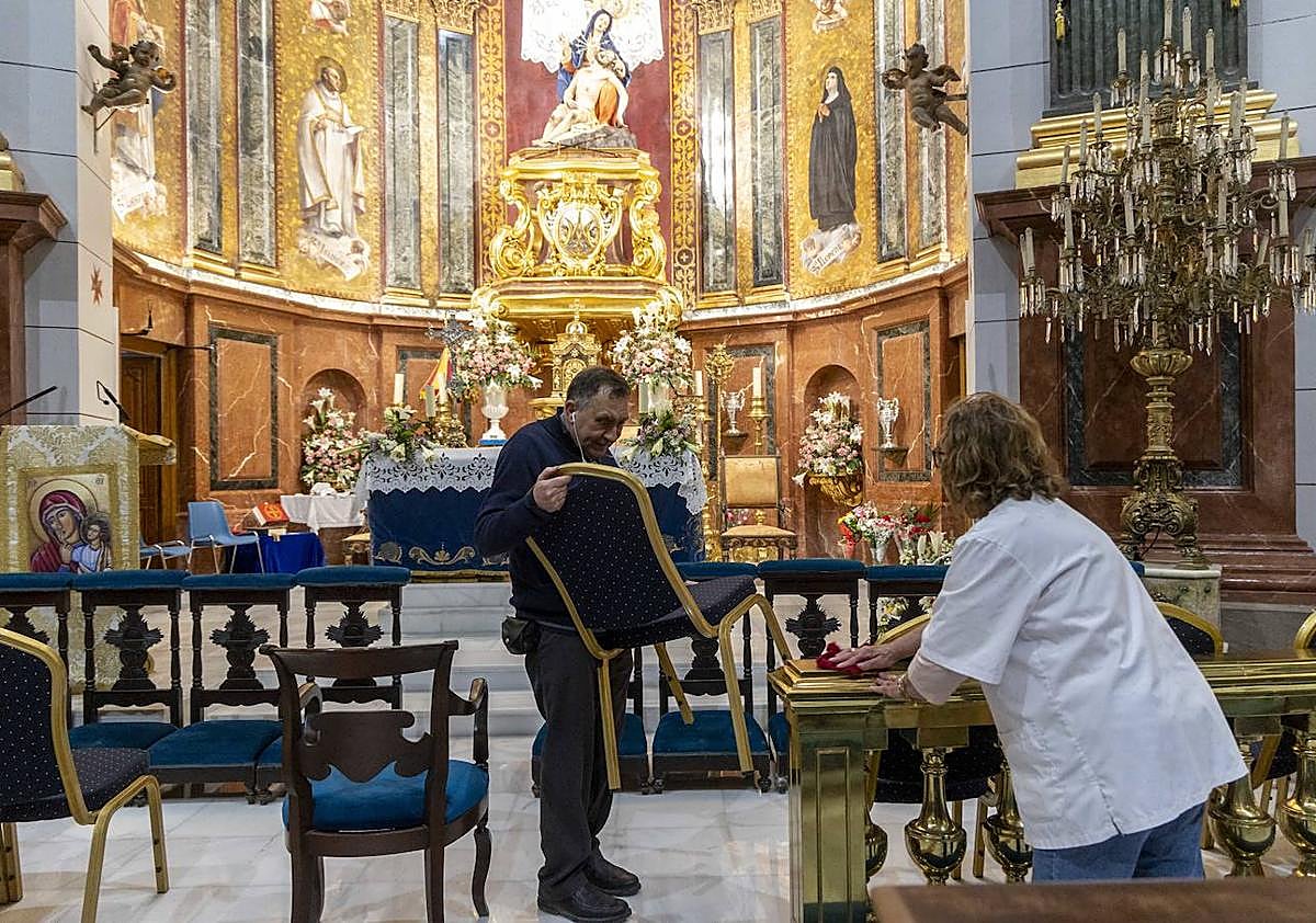 Imagen secundaria 1 - Empleados municipales colocan en la Caridad las rejillas para formar el manto de flor para la Virgen. Preparativos en el interior de la basílica para los actos de hoy. Los bomberos ponen una malla en la Casa Llagostera, de la calle Mayor.