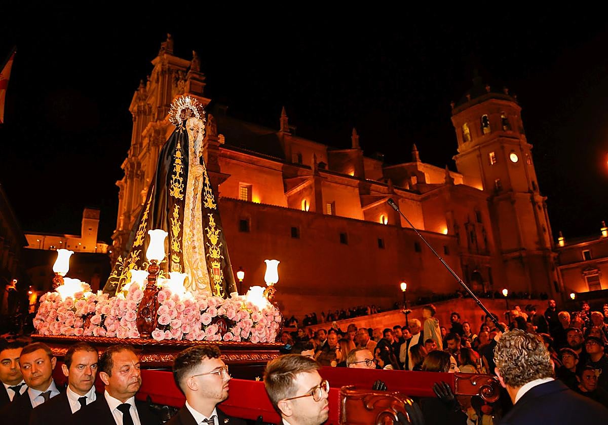 La Virgen de la Soledad en su trono en andas cruza la plaza de España ante la antigua colegiata de San Patricio repleta de gente, este sábado.