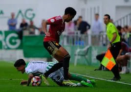 Víctor Rofino pugna con un atacante del Sanluqueño en una de las jugadas polémicas del choque de ayer.