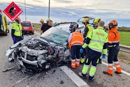 Bomberos y sanitarios atienden a la conductora que quedó atrapada en su vehículo tras el choque.