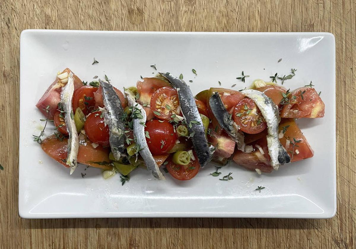 Ensalada de tomates y anchoas marinadas.