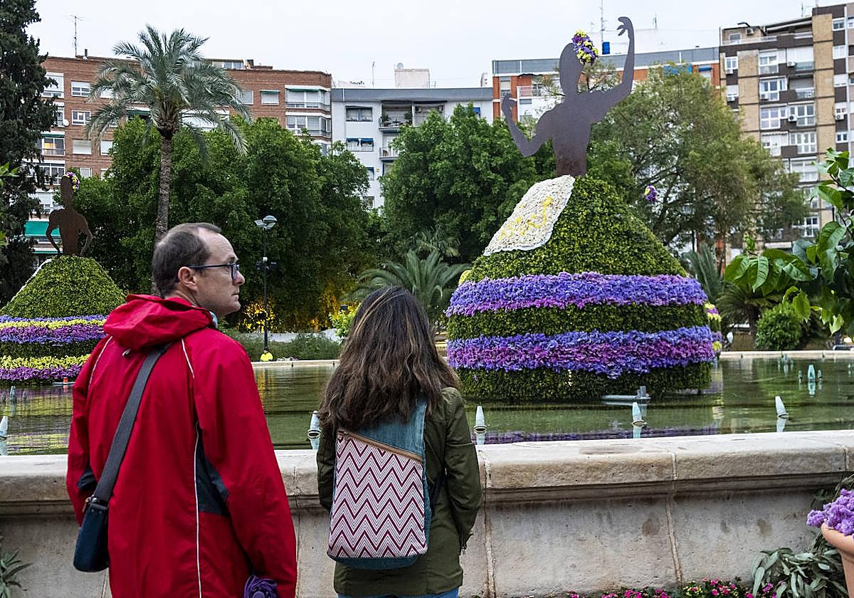 Dos personas contemplan las esculturas de flores de La Circular.