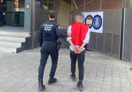 Un agente lleva al detenido a una comisaría de Murcia.