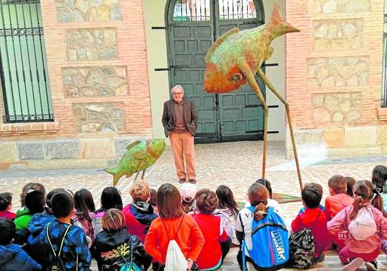 Blas Miras en una visita escolarguiada ante la escultura 'El pezgrande ayuda al chico'.