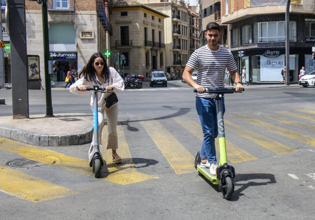 Dos usuarios del servicio de alquiler de patinetes circulando por Murcia, en una foto de archivo.