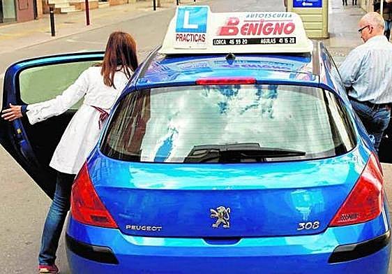 Una alumna de autoescuela accede a un coche de prácticas para comenzar una clase en Lorca, en una imagen de archivo.