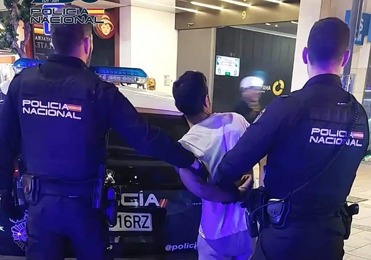 Dos agentes de la Policía Nacional con el detenido.