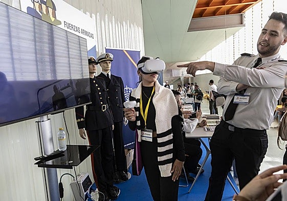 Un militar realiza una demostración virtual a varios jóvenes en el sitio montado por la Armada.