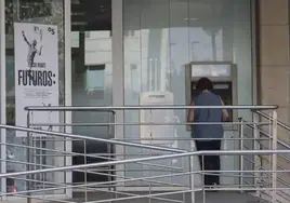 Una persona sacando dinero de un cajero automático, en una imagen de archivo.
