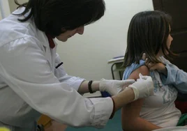 Vacunan a una niña contra la meningitis.