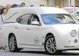 El coche fúnebre traslada los restos de Audrey Fang, seguida por familiares y amigos.