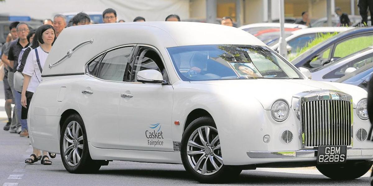 El coche fúnebre traslada los restos de Audrey Fang, seguida por familiares y amigos.