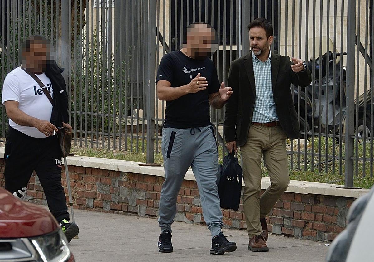 Dos de los procesados abandonan el Palacio de Justicia acompañados de uno de los abogados.