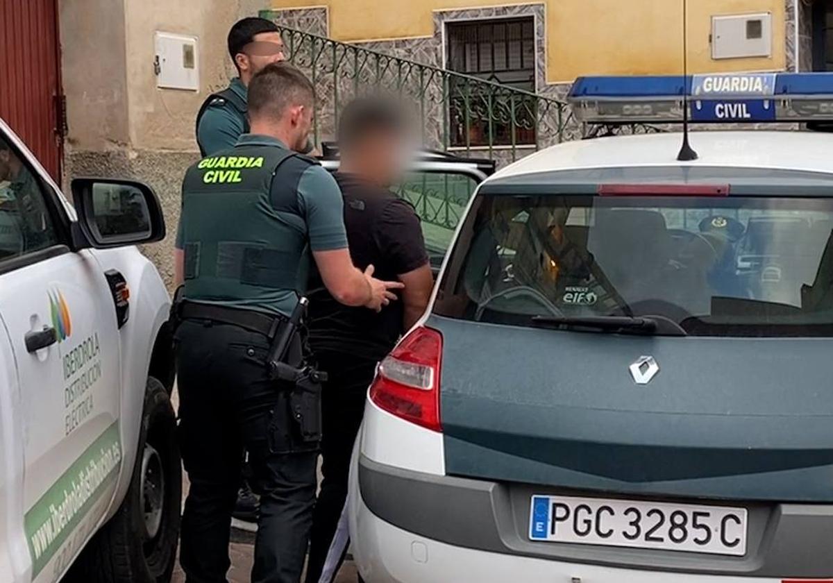 Agentes de la Guardia Civil introducen en el coche patrulla a uno de los detenidos.