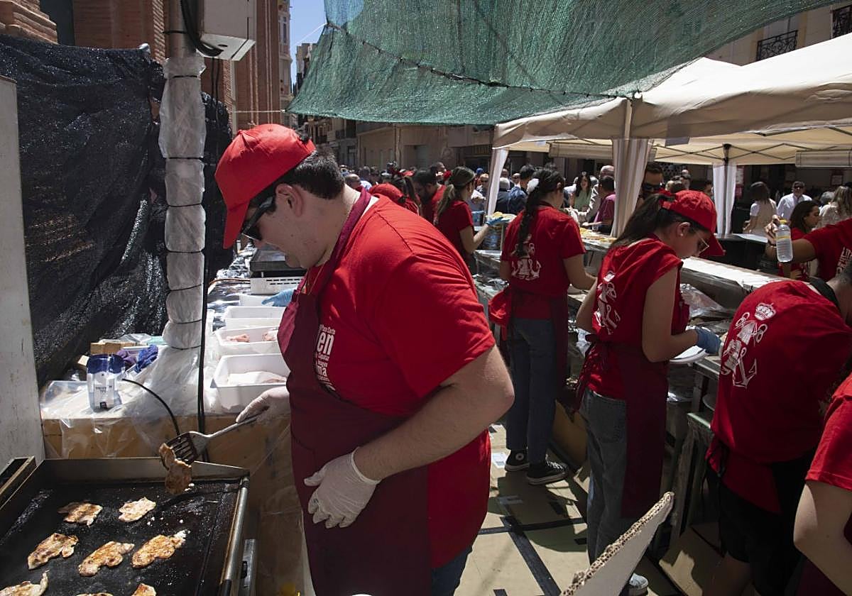 Un cocinero prepara carne en una de las barras instaladas en el casco histórico estas cruces de mayo.