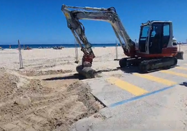 Una excavadora empieza a remover tierra junto a la playa de La Glea, con el vallado de obra ya instalado.