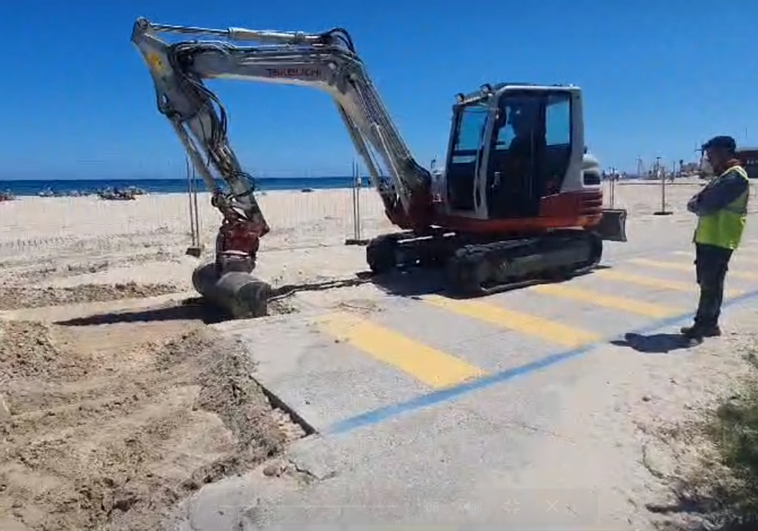 Una excavadora empieza a remover tierra junto a la playa de La Glea, con el vallado de obra ya instalado.