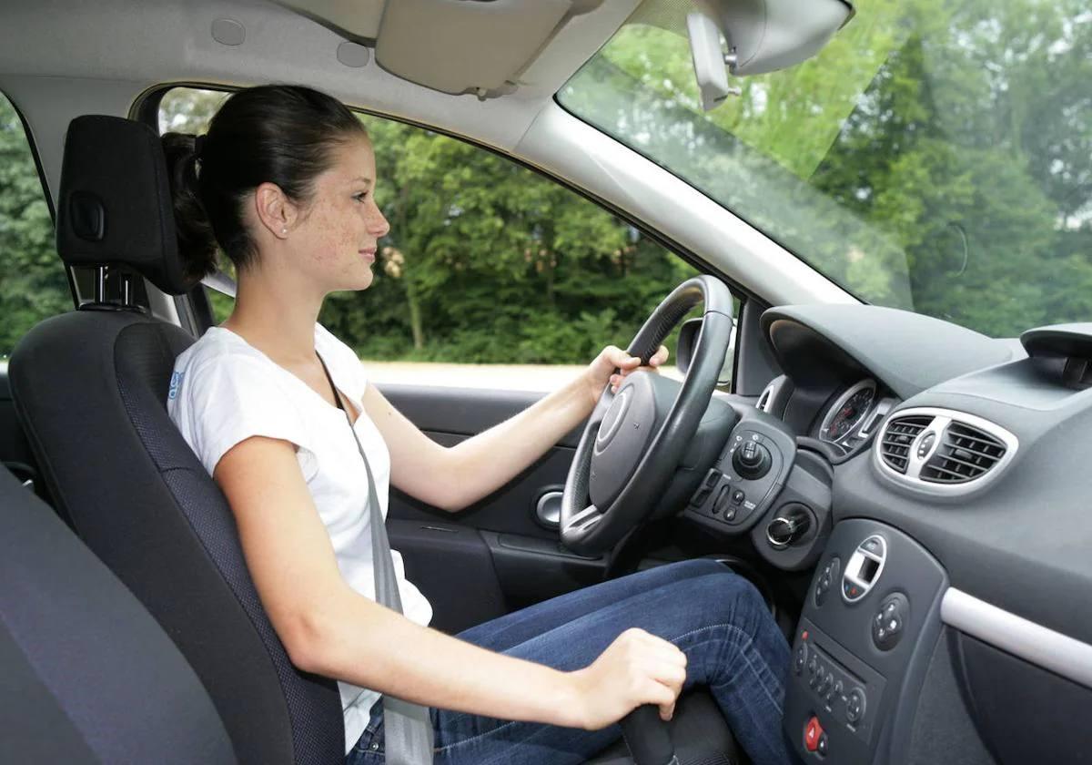 Una mujer conduce un coche.