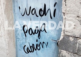 Pintada en la puerta de la vivienda incendiada el pasado 9 de mayo, donde murieron tres personas.