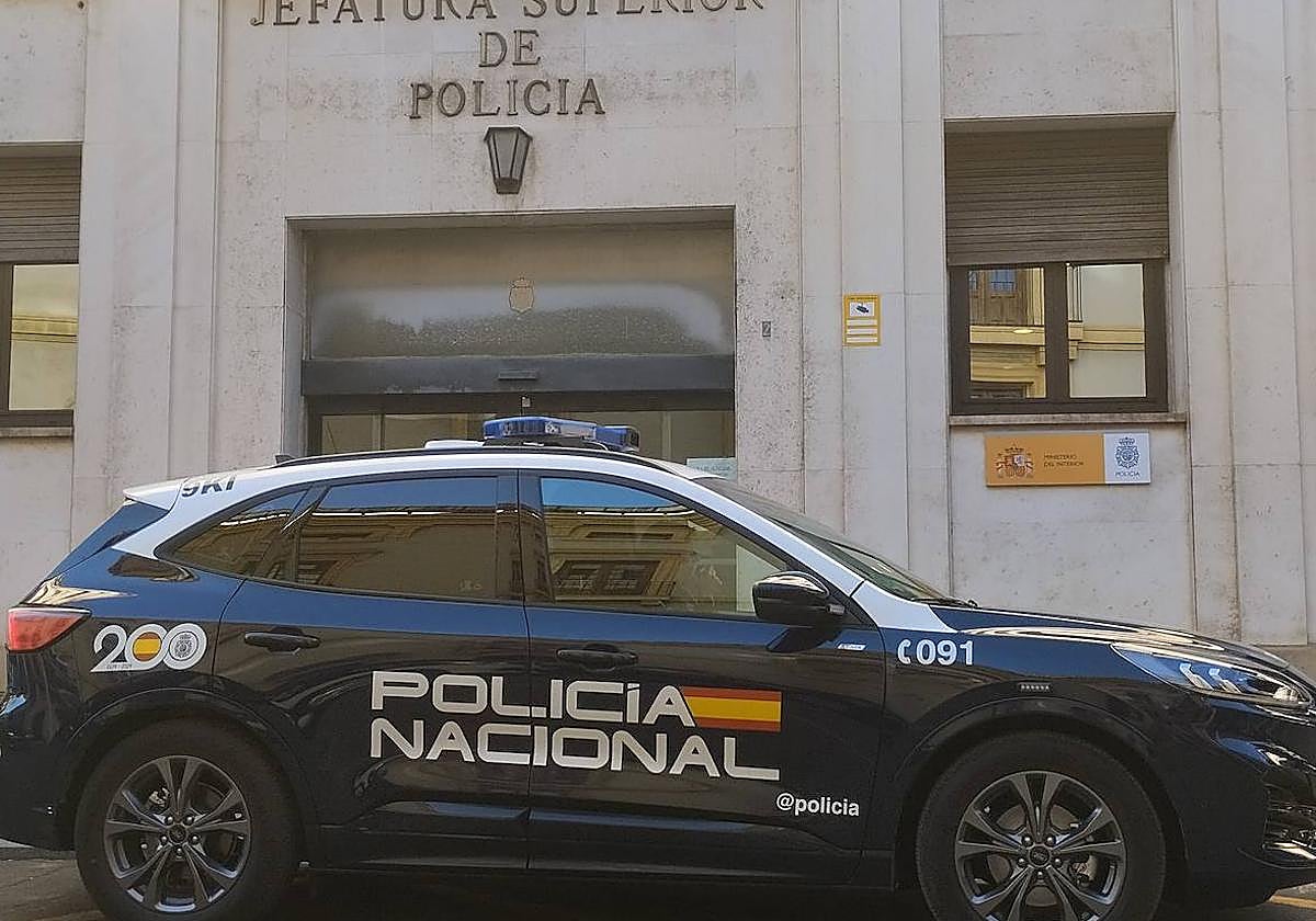Coche patrulla de la Policía Nacional estacionado delante de la puerta de la comisaría de Murcia.