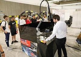 Un profesional comprueba el funcionamiento del robot de soldadura ante un grupo de estudiantes.
