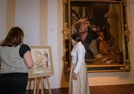 Dos visitantes observan el boceto de Ramón Gaya junto al cuadro original de Velázquez.