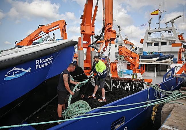 Dos marineros preparan uno de los barcos.