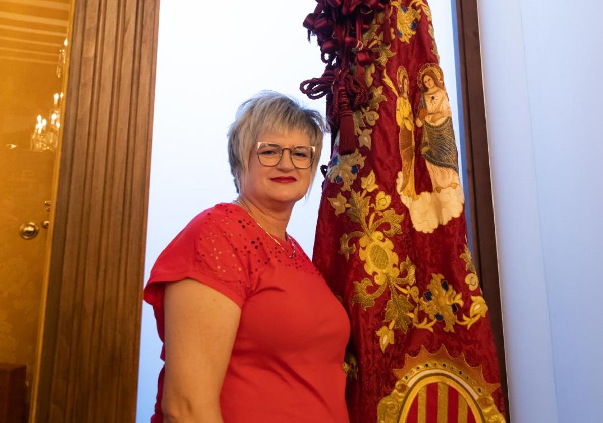 Chelo Moñino posa orgullosa junto a la Gloriosa Enseña del Oriol.