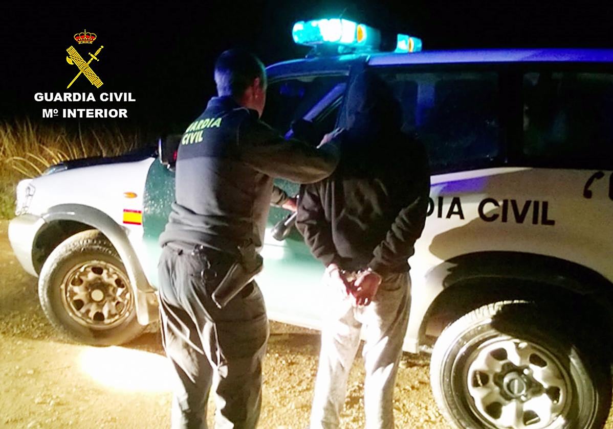 Un agente de la Guardia Civil, junto al detenido.